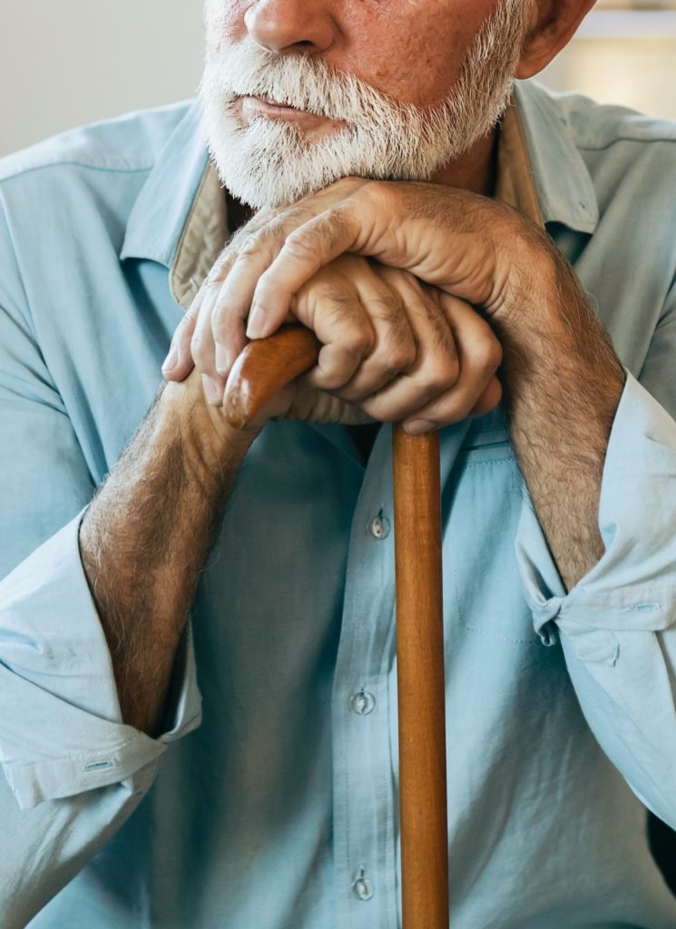 Man leaning against a cane